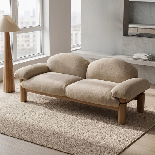 Beige sofa in a modern living room with large windows and a neutral color palette.