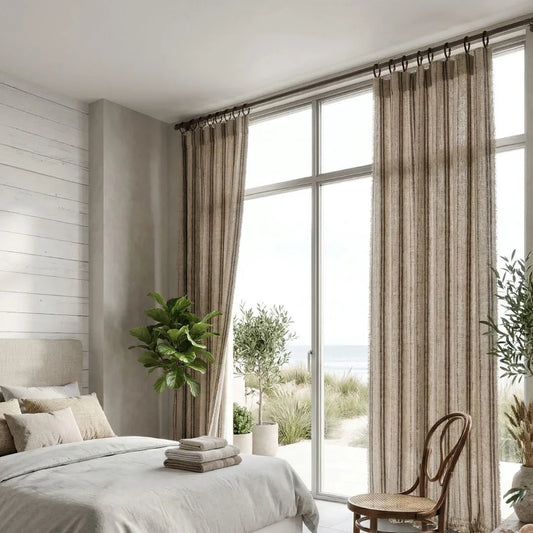 Modern bedroom with large windows, striped curtains, and decorative plants.