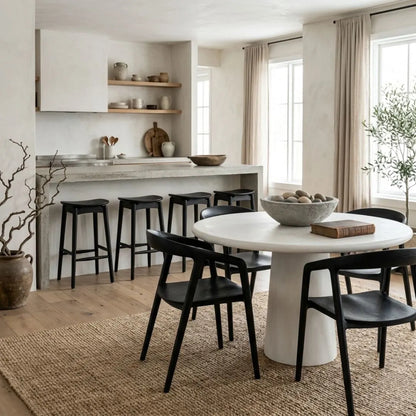 Modern kitchen with concrete island and black bar stools