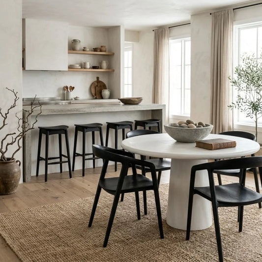 Modern kitchen with concrete island and black bar stools