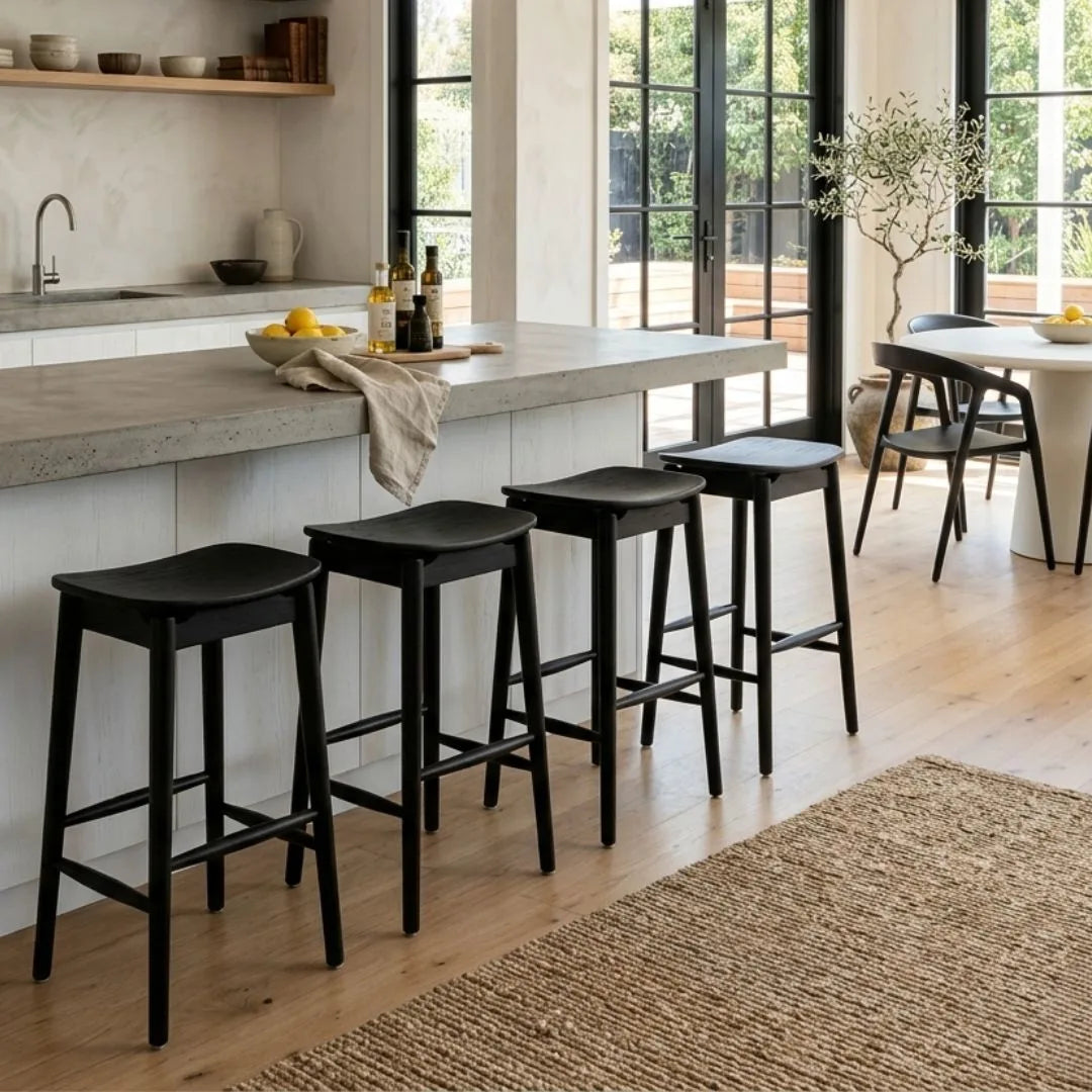 Modern kitchen with concrete island and black bar stools