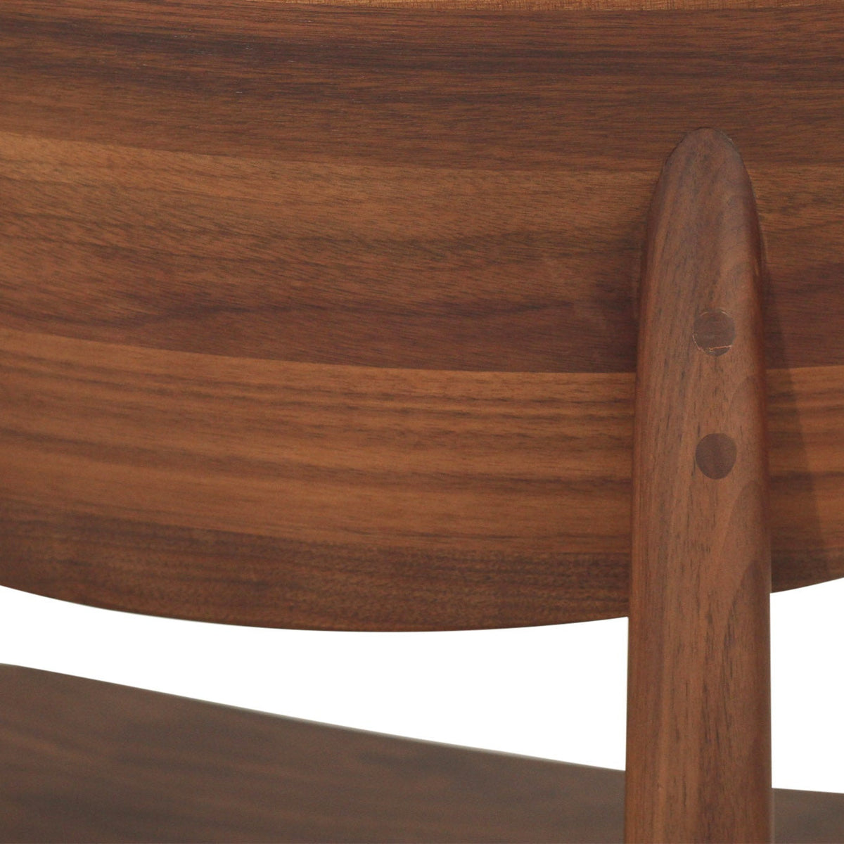 Close-up detail of a wooden chair showing the curved backrest, vertical support post, and visible double dowel joinery against a white background.