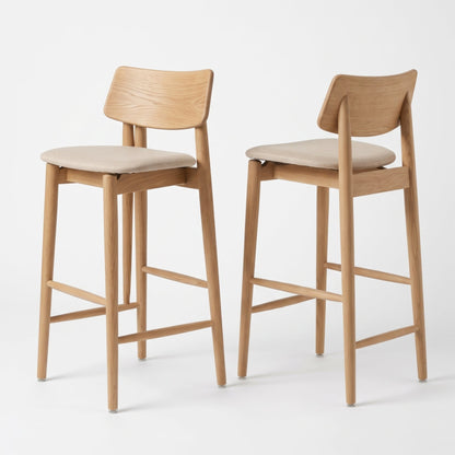 Two modern wooden bar stools with light beige upholstered seats, shown on a clean white studio background.