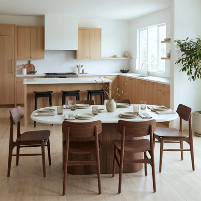 Dining area with a round table and wooden chairs in a modern kitchen.