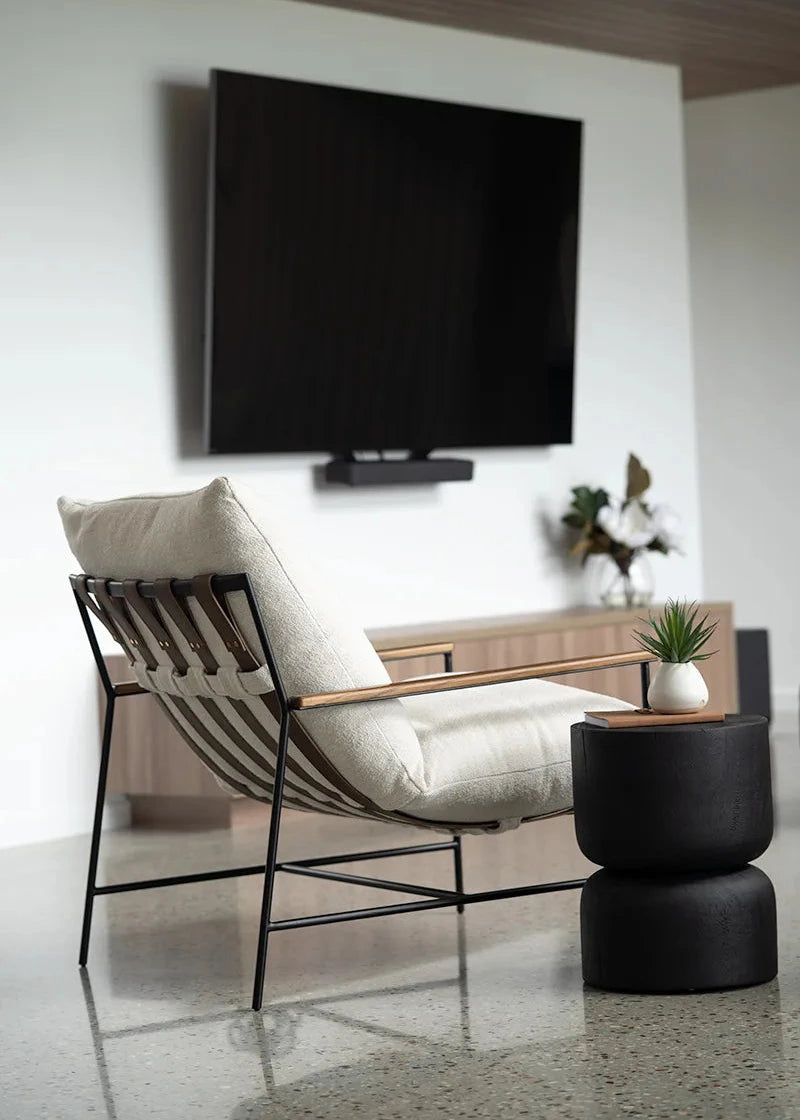 Modern living room with a chair, TV, and decorative items.