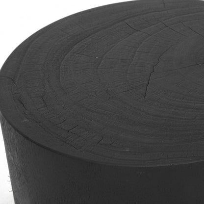 Close up of a Black round stump stool side table on a white 