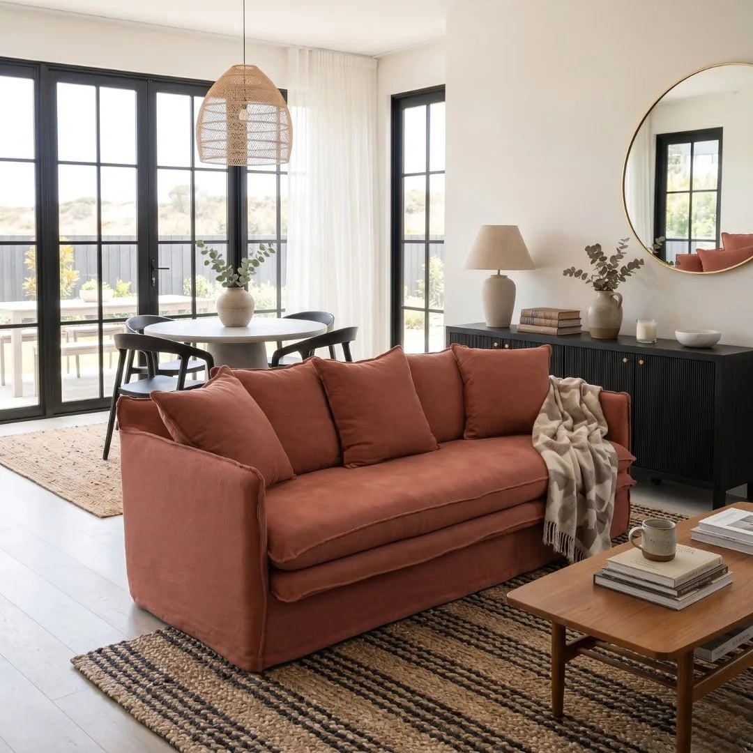 Living room with a linen desert rose colour sofa,, coffee table, and decorative items.