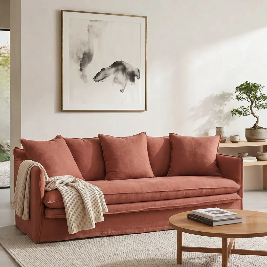 Living room with a linen desert rose colour sofa,, wooden coffee table, and framed artwork on the wall.