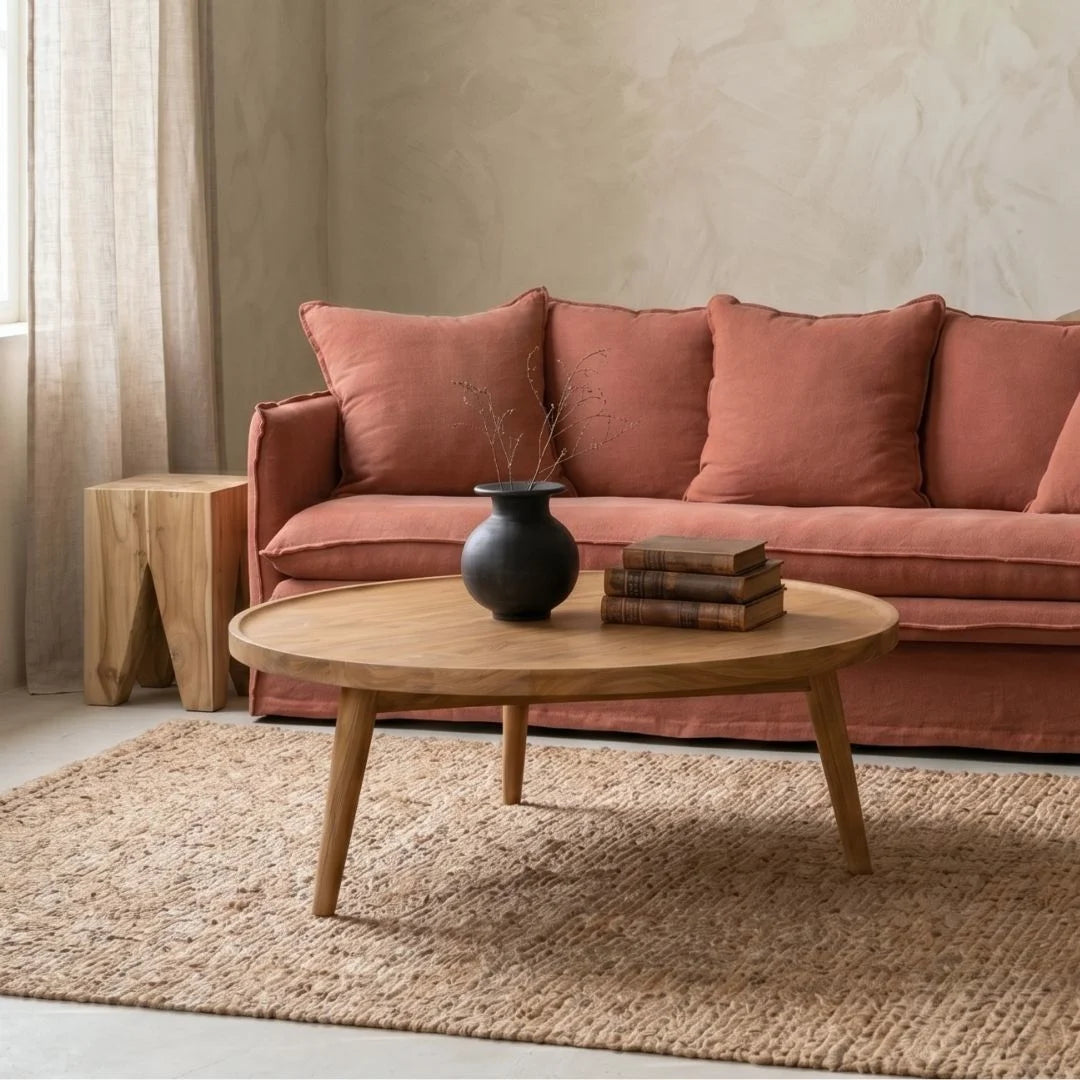 Living room with a linen desert rose colour sofa,, wooden coffee table, and decorative items.