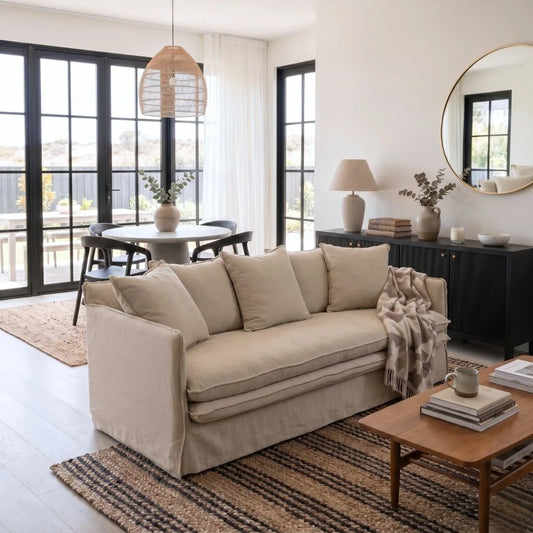 Beige sofa in a modern living room with a coffee table and decorative items.