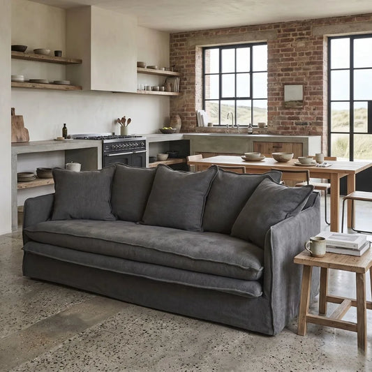 Gray sofa in a modern living room with kitchen in the background