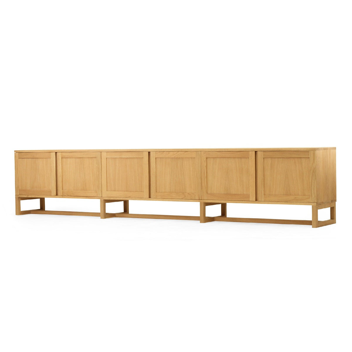 A long, low wooden sideboard or credenza with six paneled doors and open legs, shown against a plain white background.