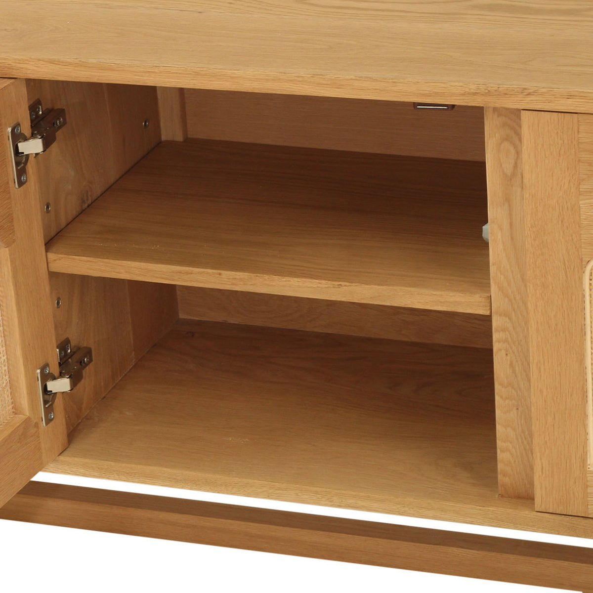 Close-up of a light oak wood cabinet with one door swung open, showing the interior shelves and woven cane panel details on the sides.