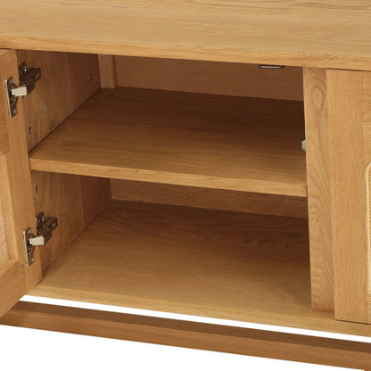 Close-up of a light oak wood cabinet with one door swung open, showing the interior shelves and woven cane panel details on the sides.