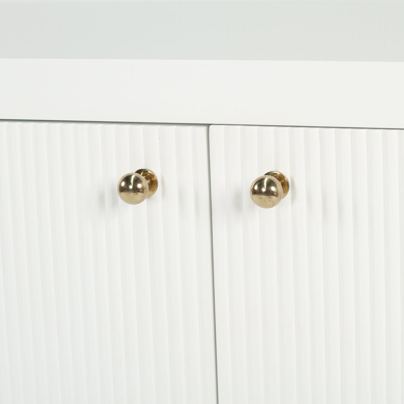 White cabinet with gold knobs on a white background