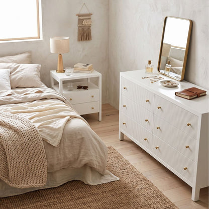 Modern white bedside table and dresser in a coastal bedroom setting