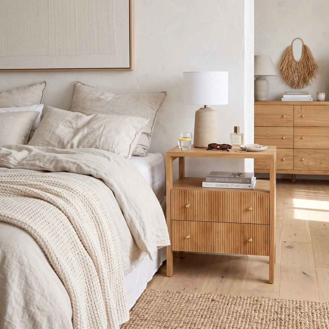 Natural teak bedside table in a modern bedroom setting
