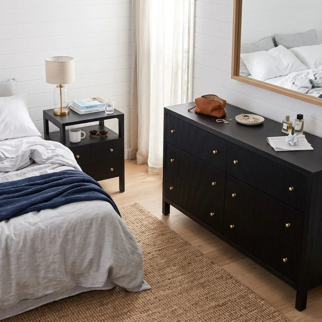 Black bedside table in a coastal bedroom setting