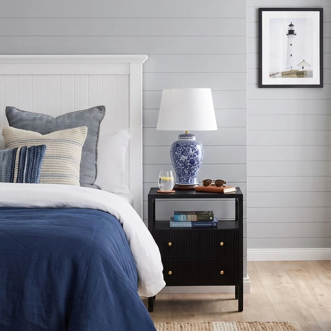 Black bedside table in a coastal bedroom setting