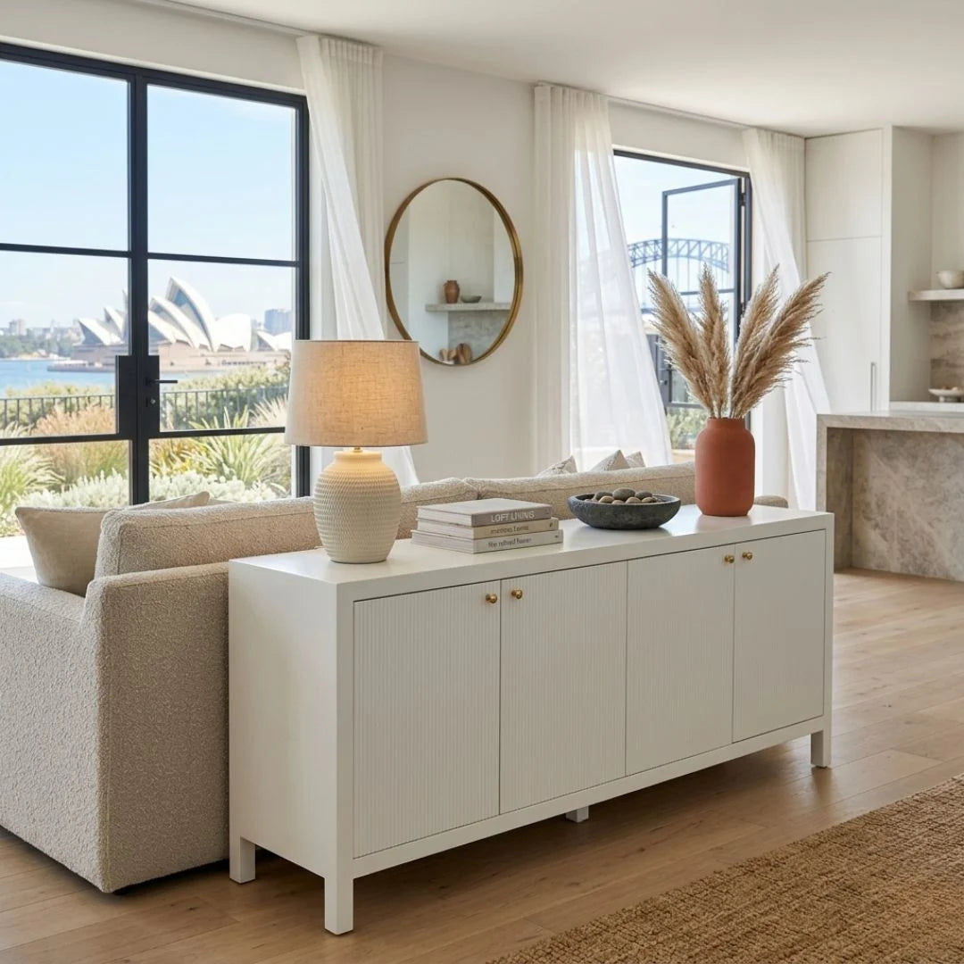 Modern living room with a white sideboard, lamp, and decor items.