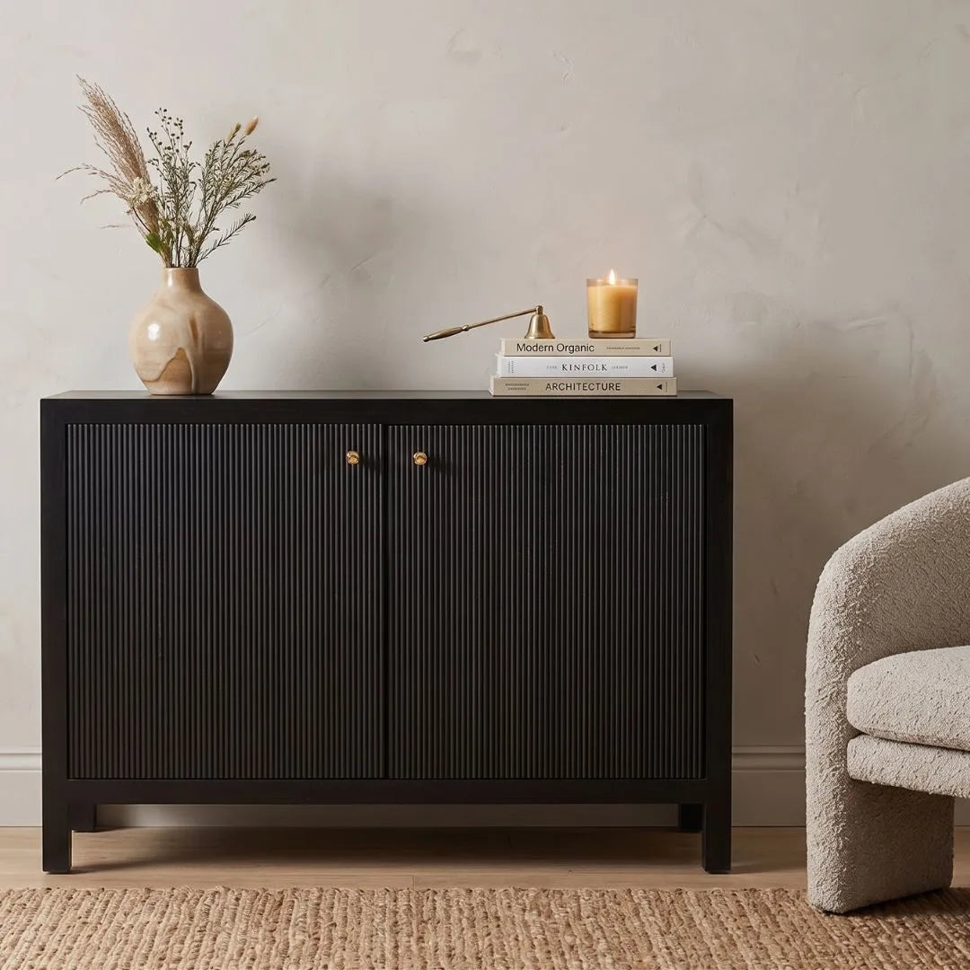 Black cabinet with decorative items on a beige wall background