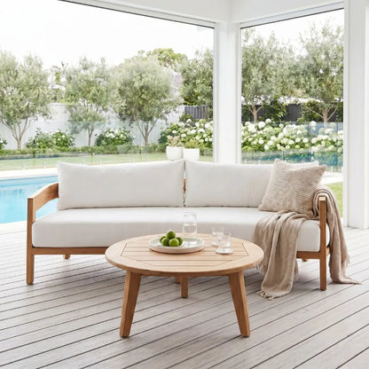 Outdoor patio set with a sofa and coffee table on a wooden deck.