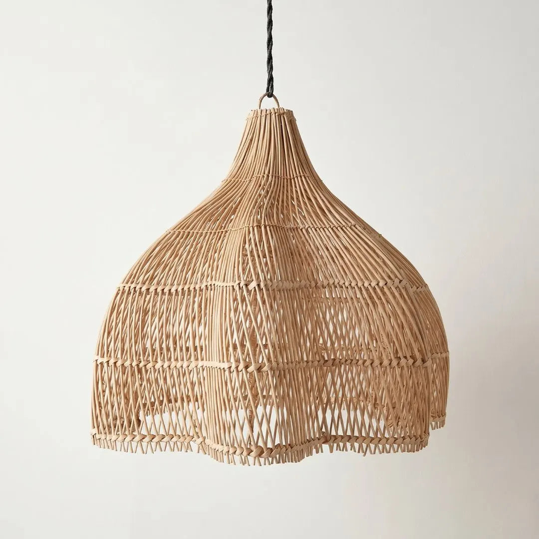 Woven rattan pendant light against a plain background