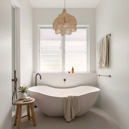 Modern bathroom with a freestanding bathtub, wooden stool, and Sun Republic Rattan Lotus pendant light.