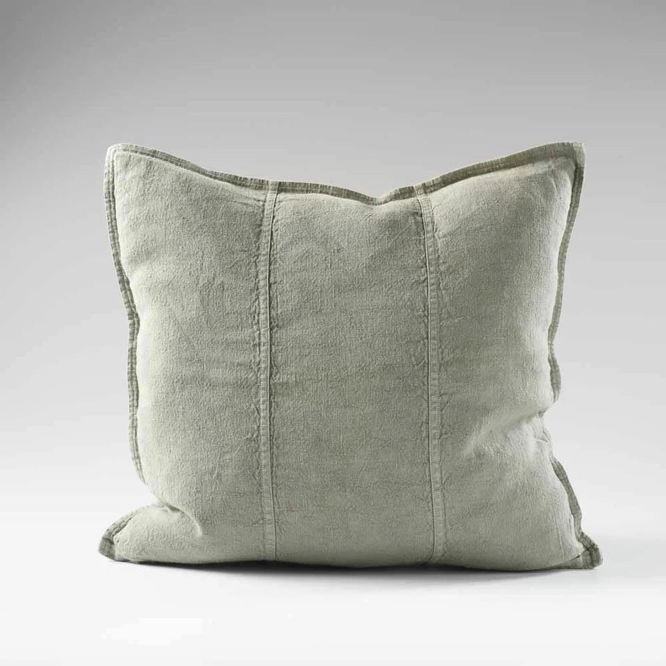 Light green pillow with textured edges on a gray background