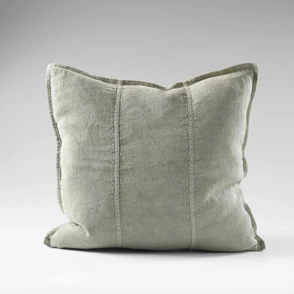 Light green pillow with textured edges on a gray background