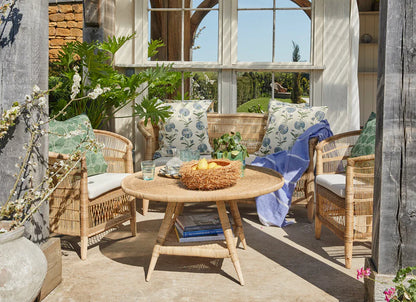 Outdoor patio with wicker furniture, table, and decorative elements.