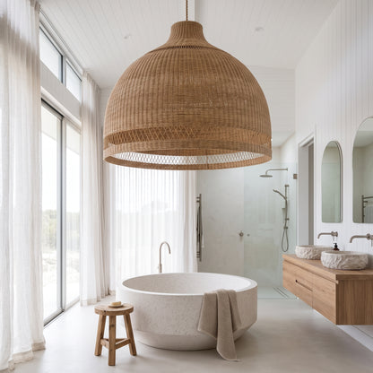 A large woven natural-fiber dome pendant light hangs over a round freestanding bathtub in a bright, modern bathroom with white walls, glass shower enclosure, wood vanity, and stone sinks.