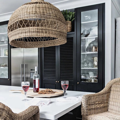 Dining area with wicker chairs and a large woven pendant light in a modern kitchen.