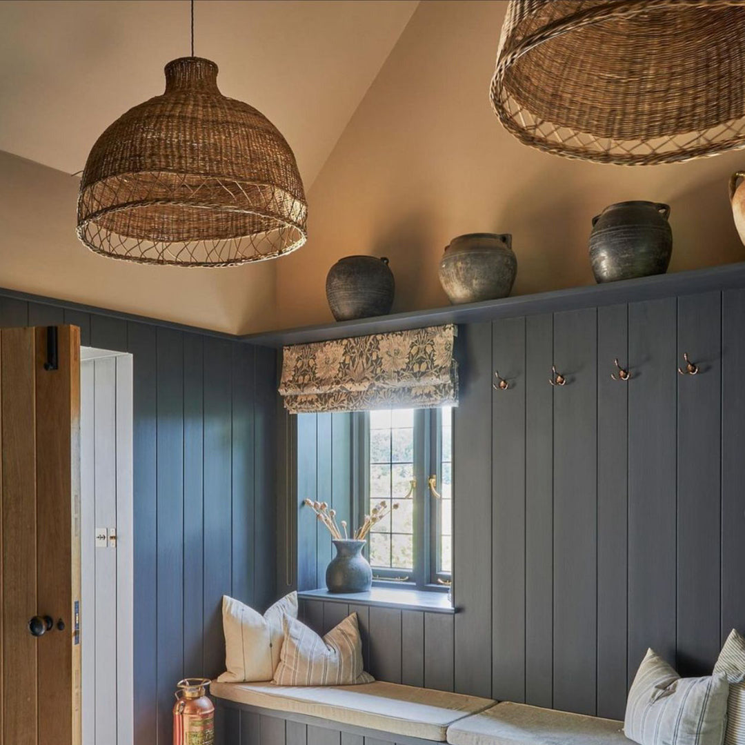 Nook with wooden bench, decorative pillows, and hanging wicker lights.