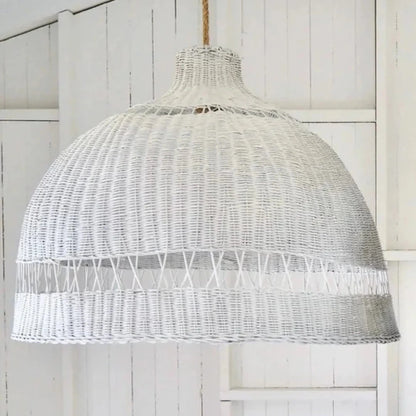 White wicker pendant light hanging against a white wooden background