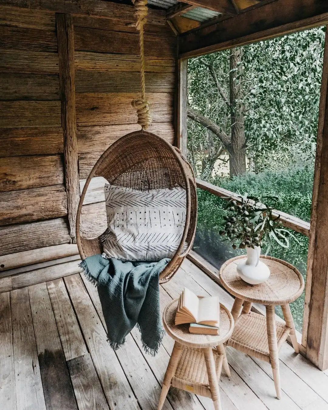 Woven Cane Hanging chair with a blanket on a porch