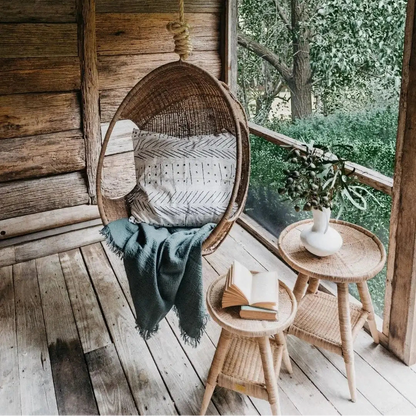 Woven Cane Hanging chair with a blanket on a porch
