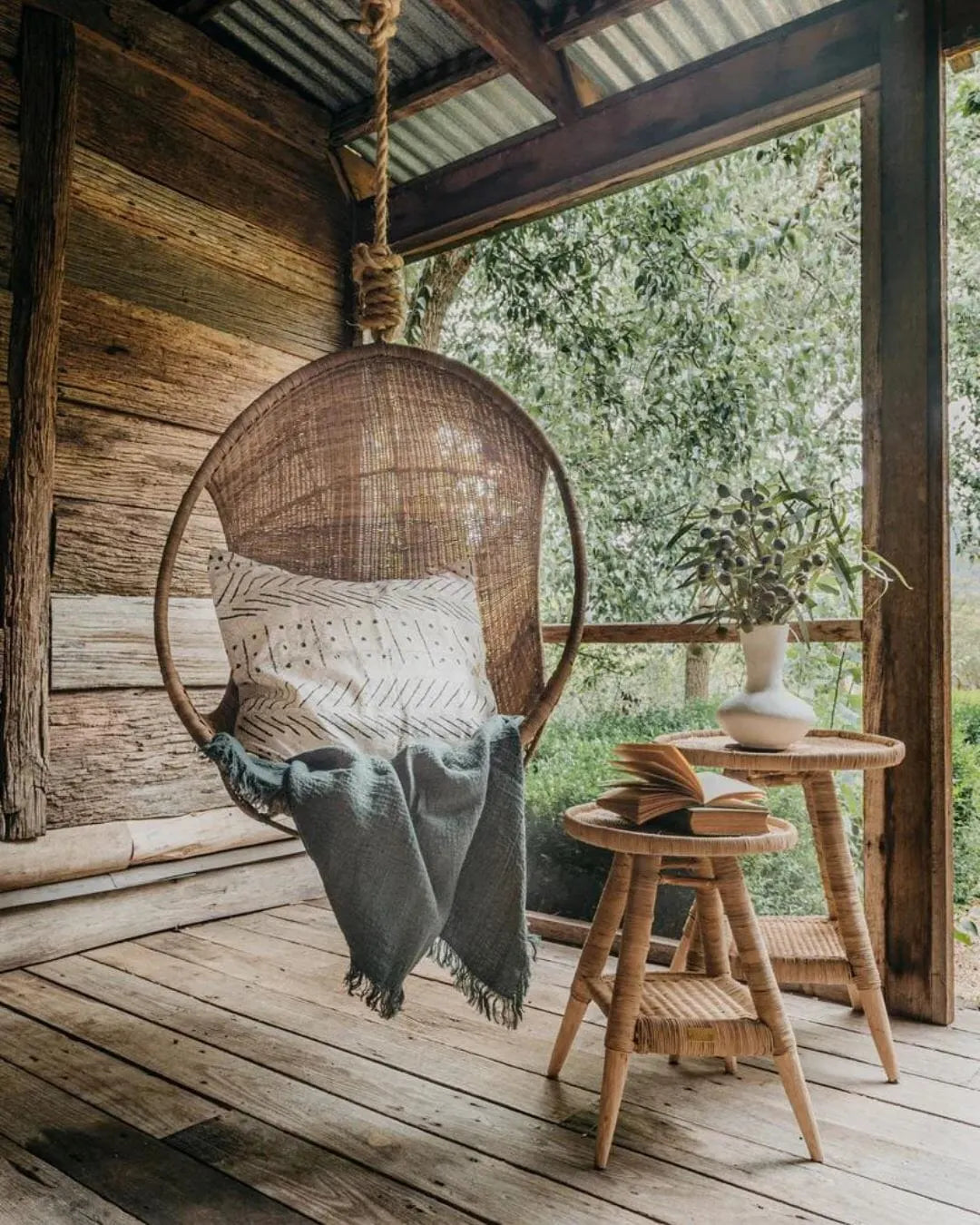 Woven Cane Hanging chair with a blanket on a porch