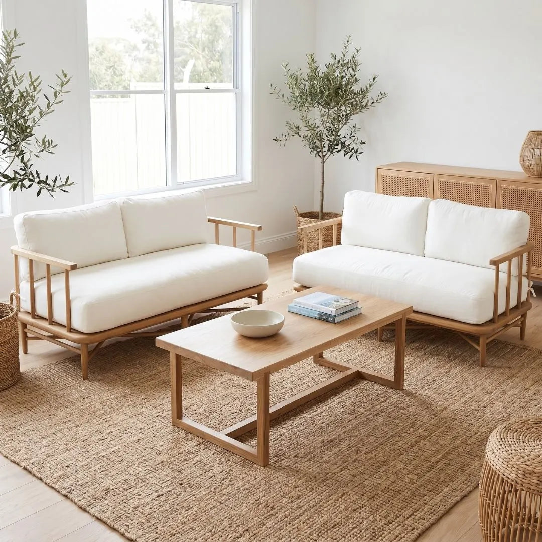 Modern living room with white sofas, wooden coffee table, and plants.