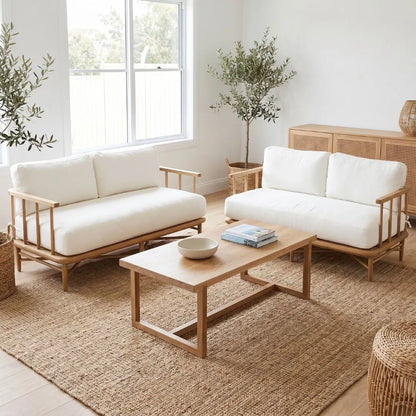 Modern living room with white sofas, wooden coffee table, and plants.