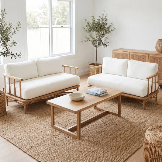 Modern living room with white sofas, wooden coffee table, and plants.