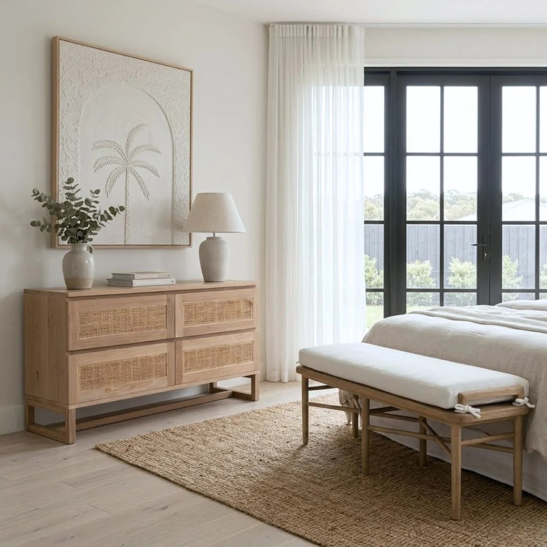 Modern bedroom with wooden dresser, bench, and large window.