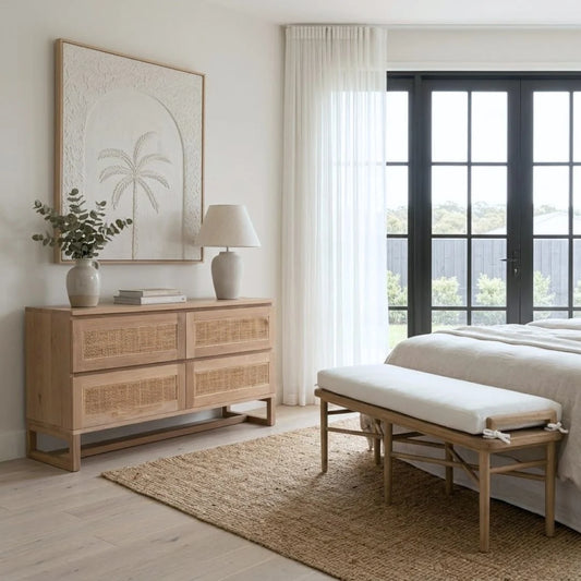 Modern bedroom with wooden dresser, bench, and large window.