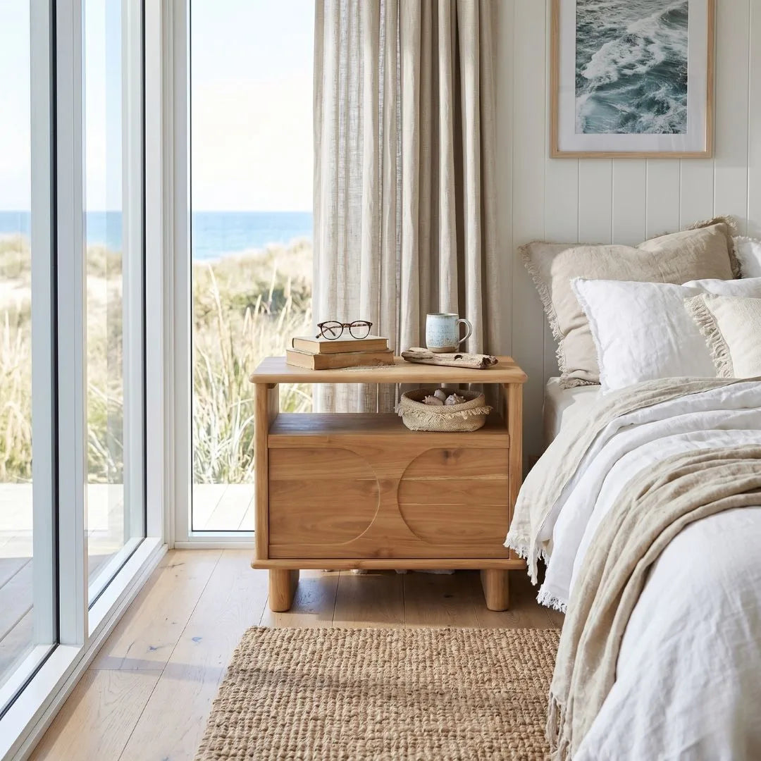 Sun  Republic Mea Teak nightstand in a bedroom with large windows and ocean view