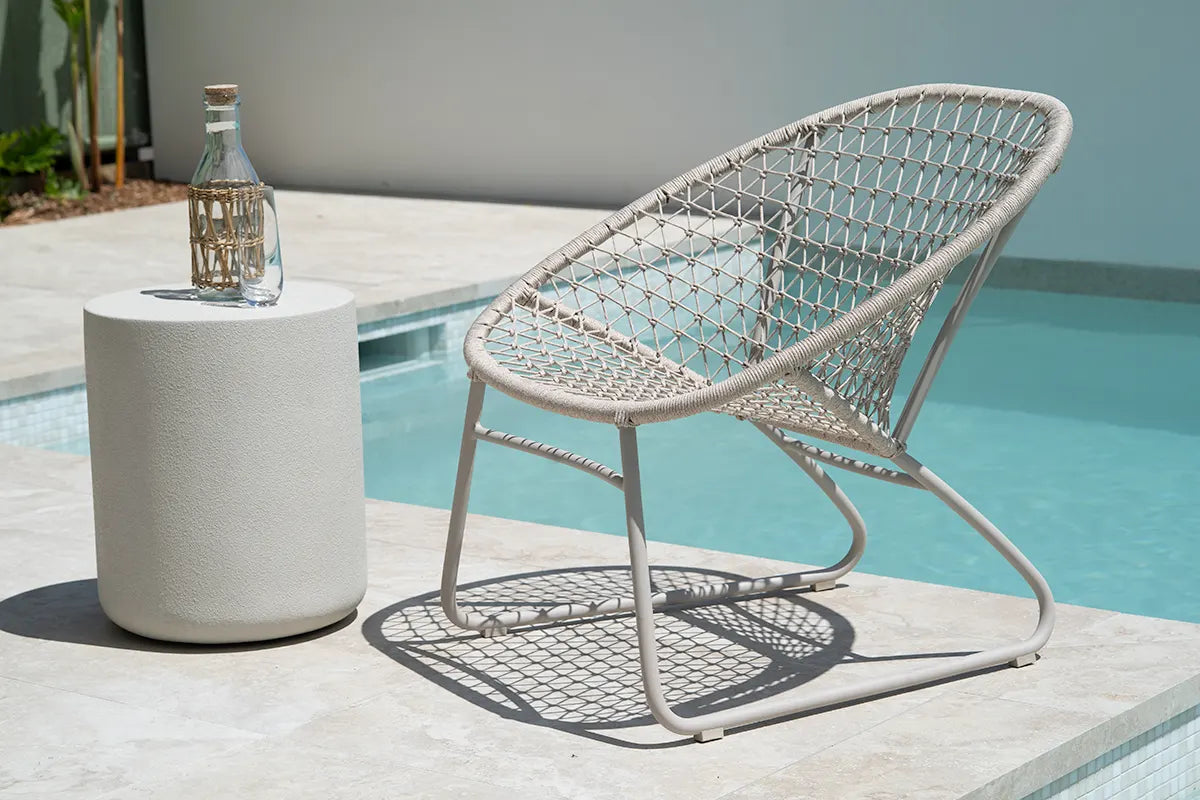 Wicker chair and side table by a poolside