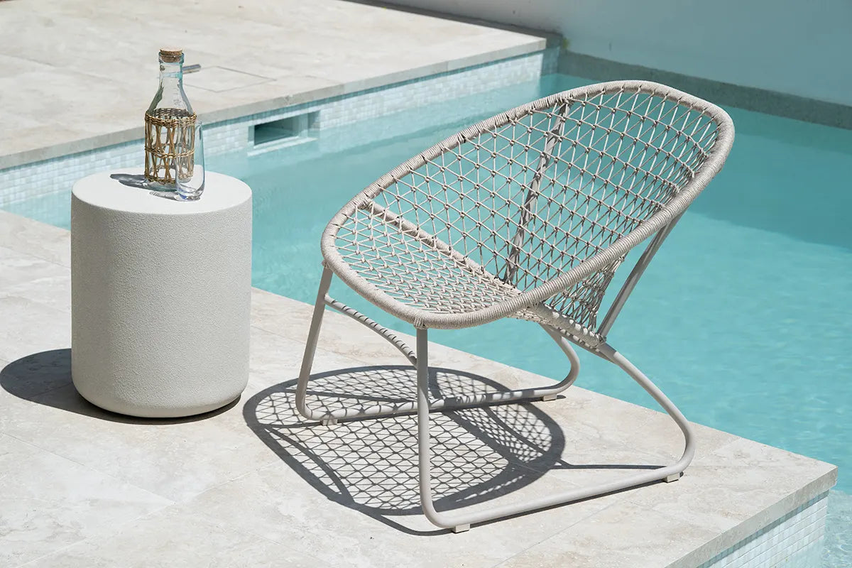 Woven chair and side table by a poolside