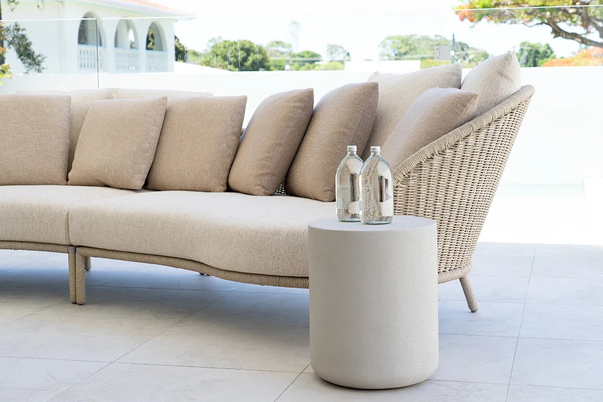 Beige outdoor sofa with a matching side table on a patio