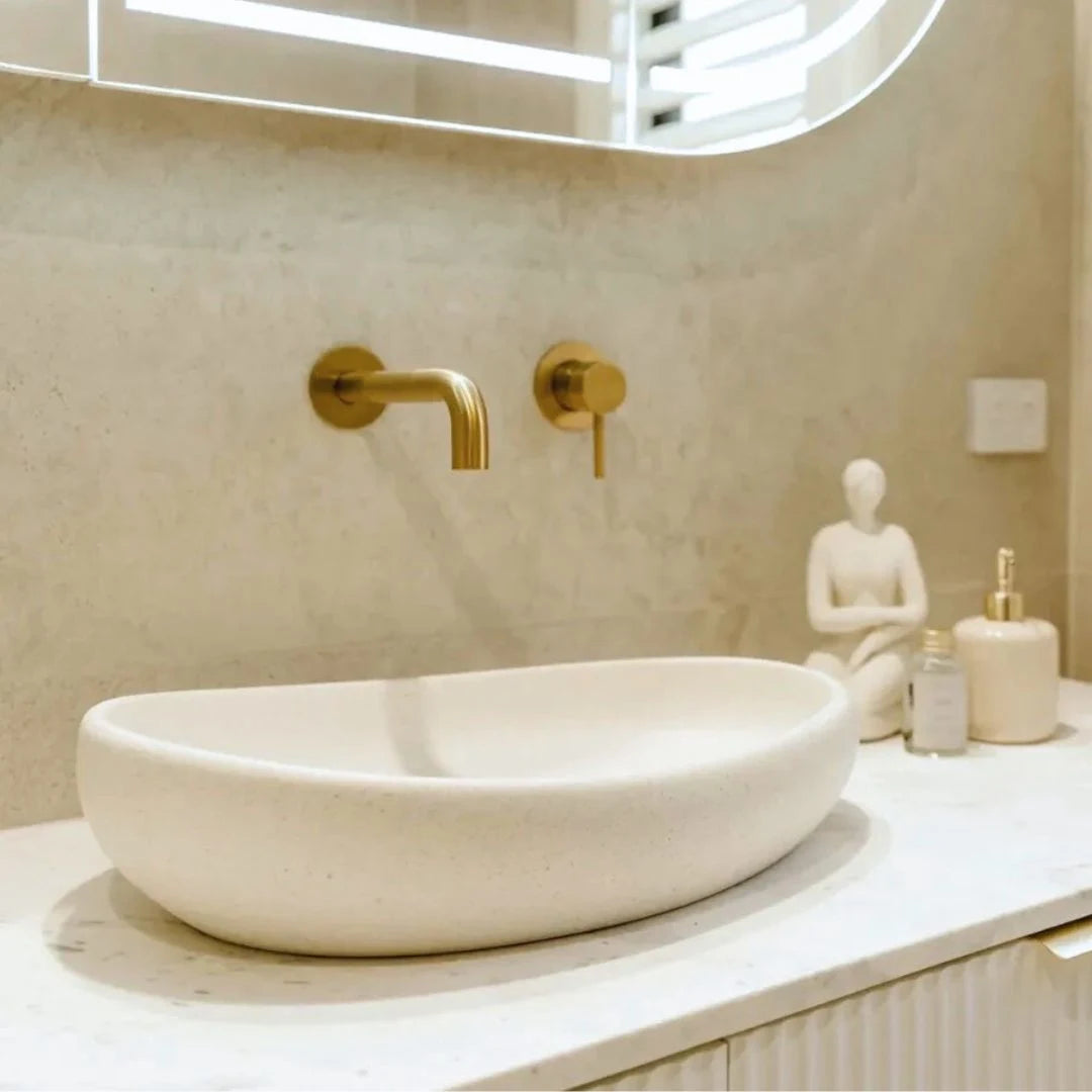 Bathroom sink with gold faucet and marble countertop