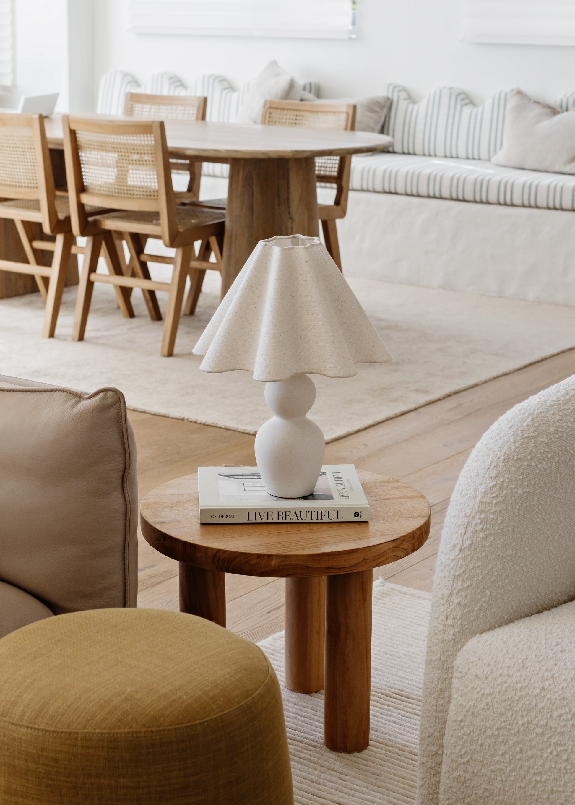 Modern living room with wooden table, chairs, and a lamp.