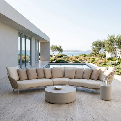 Modern outdoor furniture set with beige cushions on a patio with ocean view